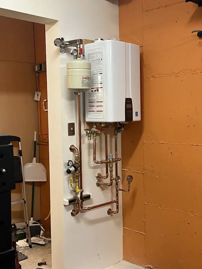 Plumbing technician inspecting water heater connections in North Branch